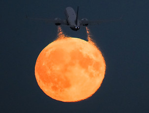 Aircraft emitting a redish round fume