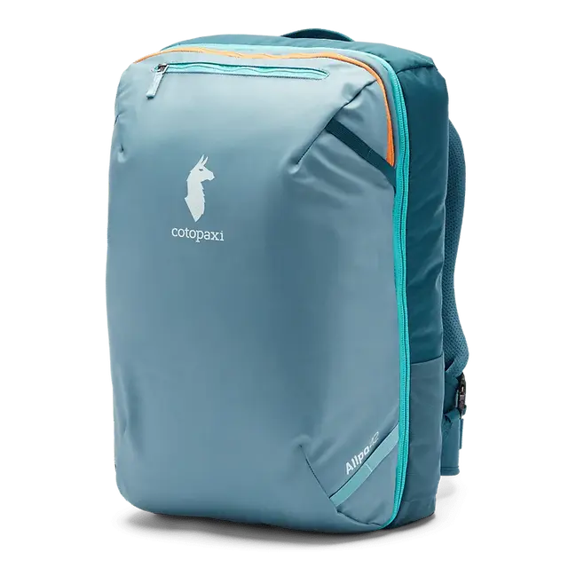 Close-up of the Cotopaxi Allpa 42L backpack in olive green with orange and blue zips, showing internal mesh pockets, key clip, and pack guide storage in the front compartment.