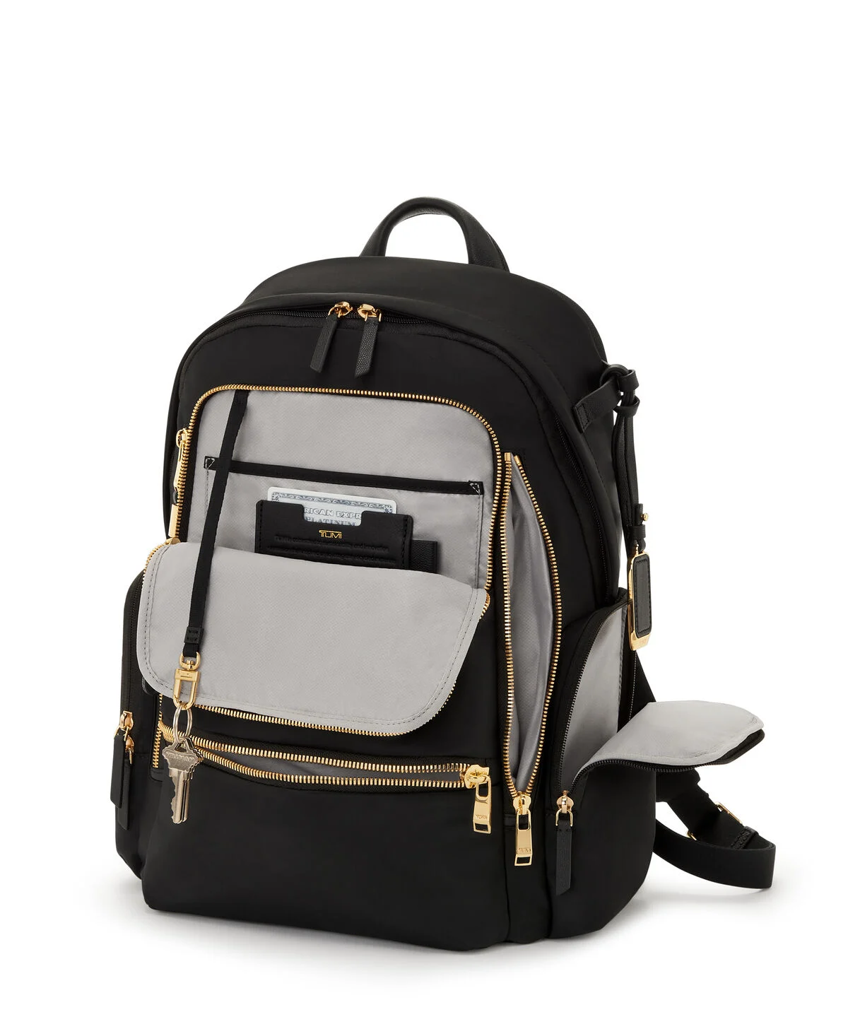 Tumi Voyageur backpack in black with gold zips, shown open to reveal grey interior compartments including key clip, card holder, and organisational pockets.