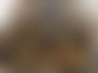 Brick building on a corner with "Dr. Martens" signage. Large windows, warm interior lighting, and street signs visible on a rainy day.