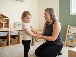 Provider calmly supporting a child with big emotions in a cozy A Village Childcare home daycare room.