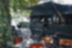 Schwarzer Campingwagen mit Gartenmöbeln