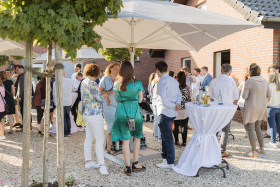 Großes Treffen im Freien, viele Leute unter Sonnenschirmen