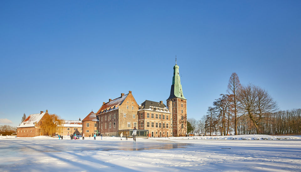 Eislaufbahn vor Schloss, sonniger Wintertag