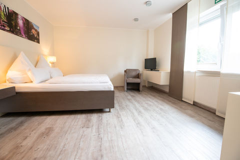Modernes Hotelzimmer mit Doppelbett und TV