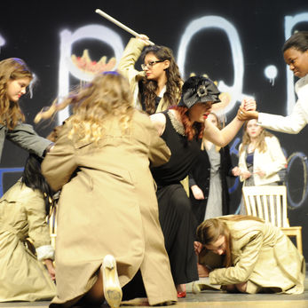 The conspirators attack Julius Caesar (Noel Bartniski) who begins to fall to the ground.