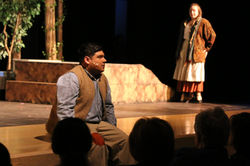 The Baker (Jacob Lara) sits on the edge of the stage, exhausted by his quest, while his wife (Katie