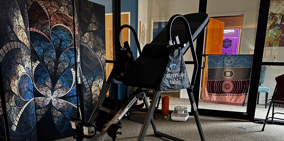Black inversion table next to a decorative screen