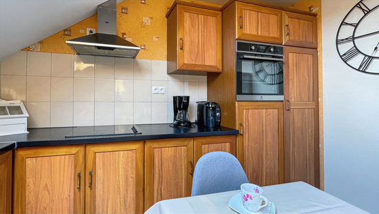 Modern fitted kitchen with hob, oven and extractor hood at the Le Foulon gîte.