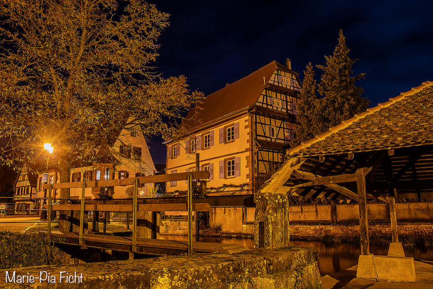 Traditioneel Elzasser vakwerkhuis, 's nachts verlicht, aan de oever van het kanaal in Wissembourg.