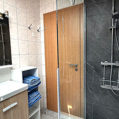 Salle de bain moderne avec douche à l'italienne en carrelage noir et meuble vasque.