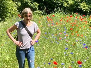 Julia May geht über eine Blumenwiese
