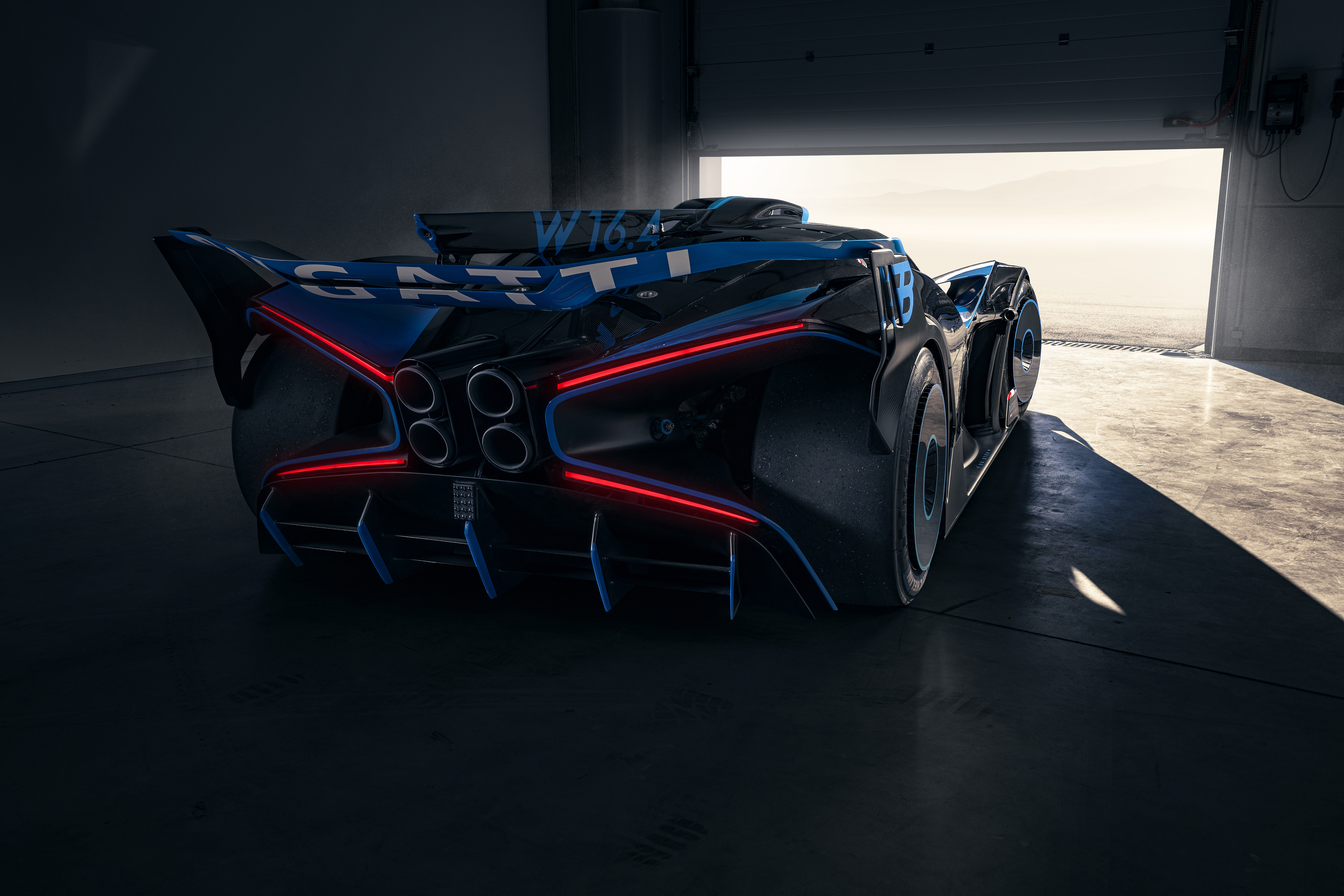 Rear three-quarter view of Bugatti Bolide showing rear wing, triple-layer diffuser, and red LED light accents