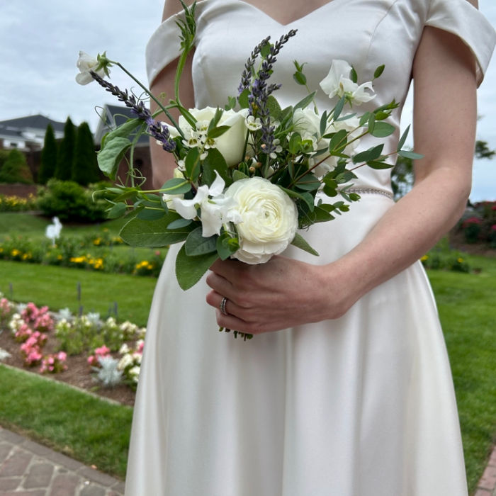 Bride holding a white floral bouquet with lavender