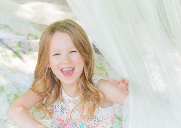 Light and bright portrait of smiling child during mommy and me photo session. 