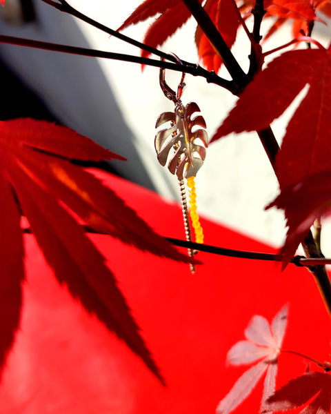 Gold plated leverback earring with monstera leaf and yellow agate beads.