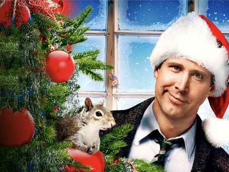 Clark Griswold from Christmas Vacation wearing a Santa hat stands beside a decorated Christmas tree with ornaments, representing the risks of building retirement plans on uncertainty instead of guaranteed income and financial stability.