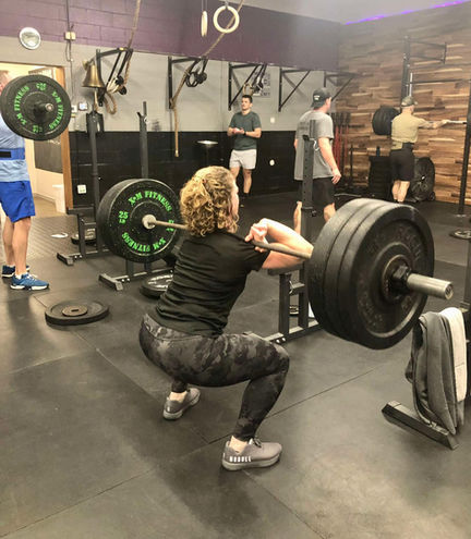 woman squatting with weight at a gym in Orillia