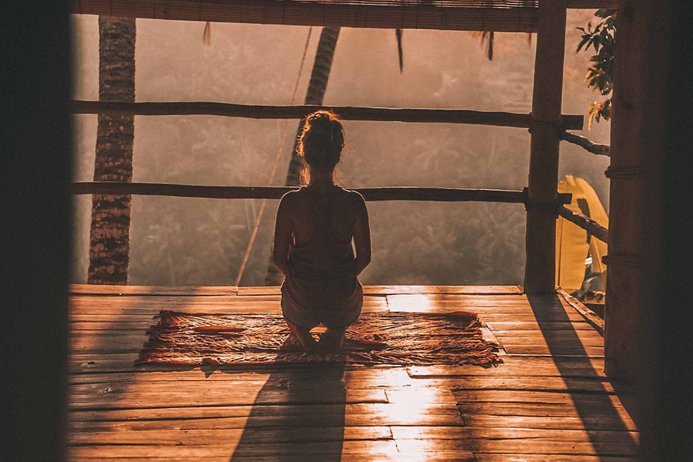 Woman meditating in a wooden shack