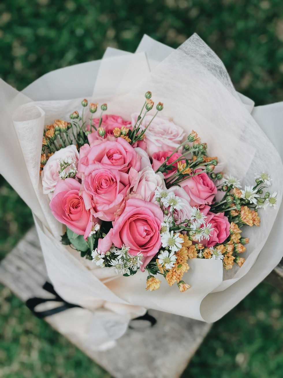 Hand-tied bouquet of pink roses and seasonal flowers