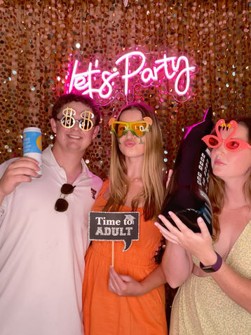 3 guests posing with. oversize props for graduation party