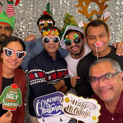 Large group of guests in Austin, smiling and enjoying photo booth with Christmas props