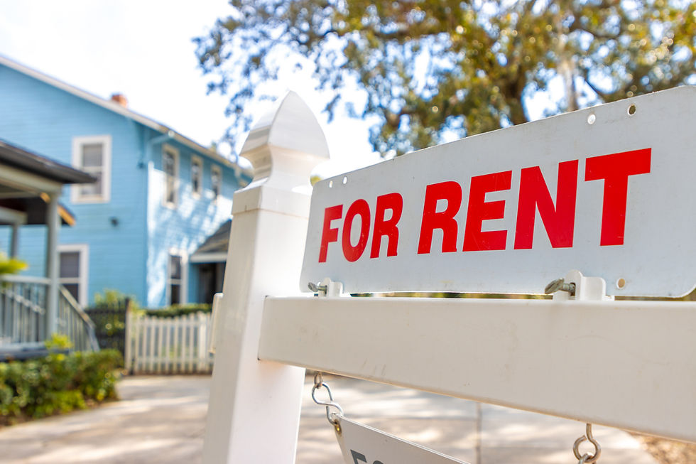 For Rent sign in front of a residential house on a sunny day, representing a rental property being prepared for summer tenants.