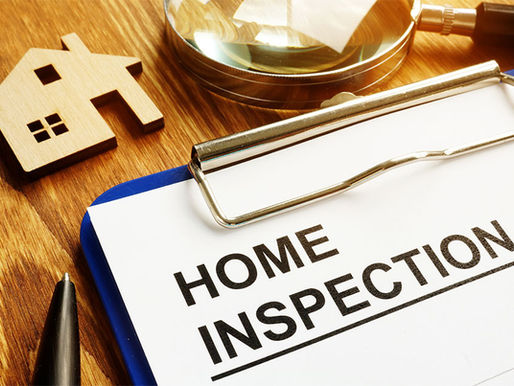 Clipboard with a home inspection checklist beside a wooden house and magnifying glass, representing routine rental property inspections.