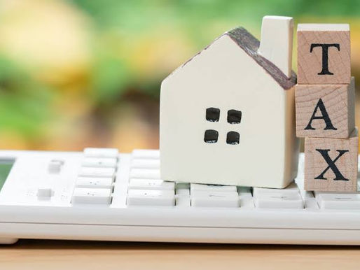 House model with tax blocks on a calculator representing end of year tax planning for New Zealand rental property owners.