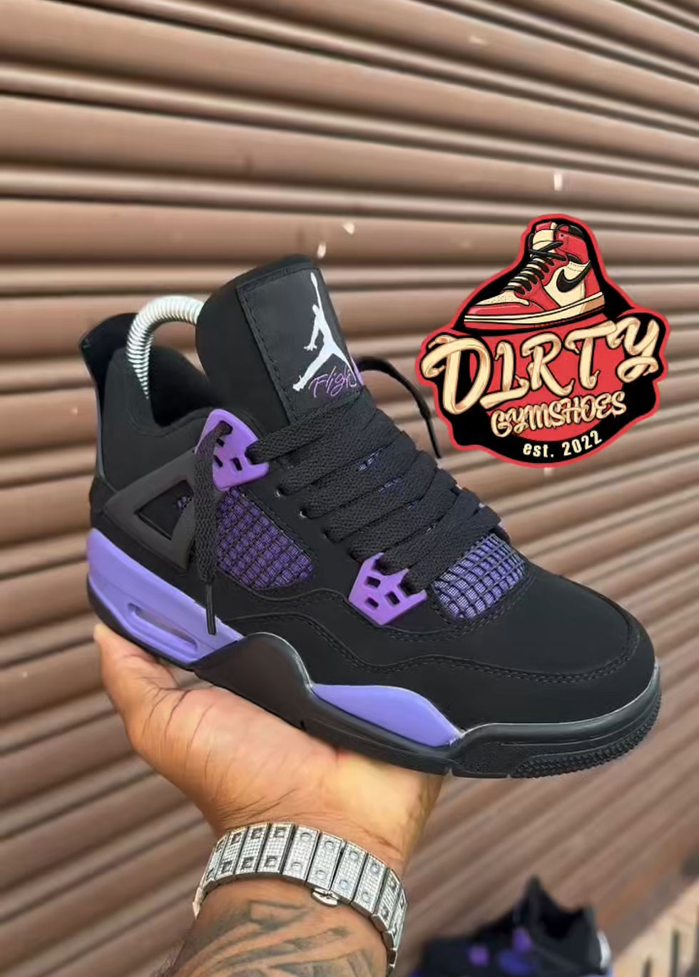 Person holding black and purple Jordan sneaker