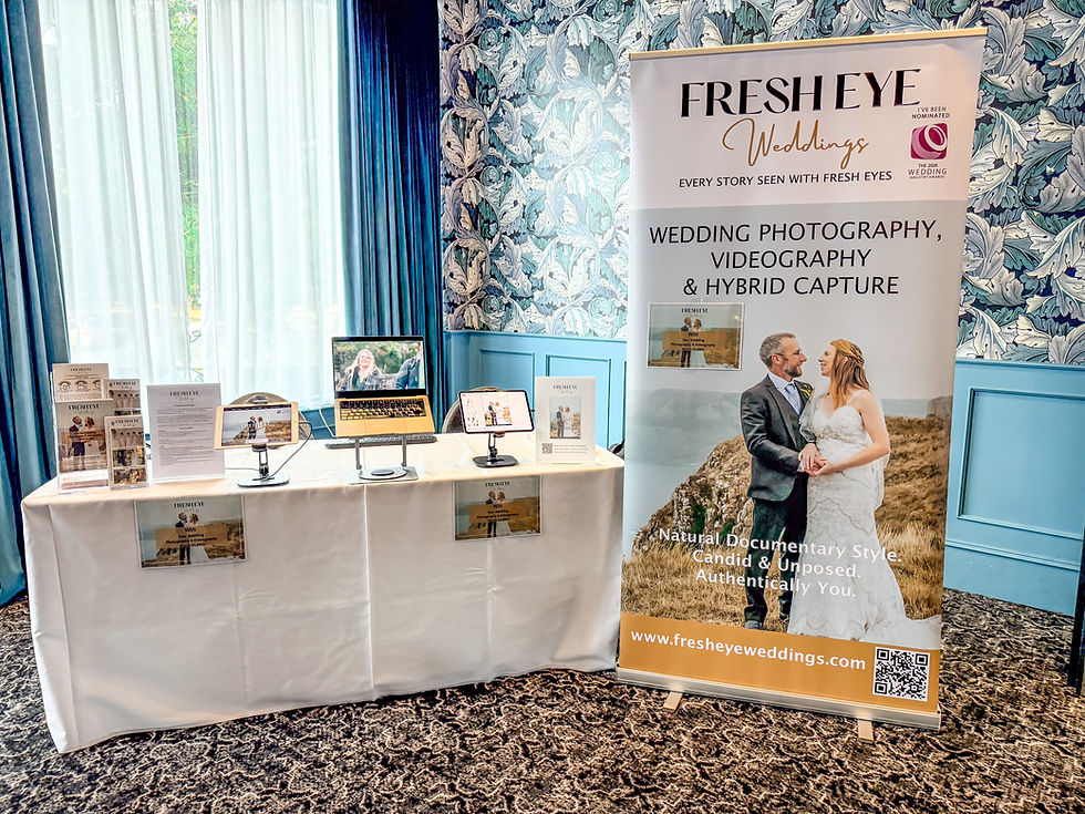 Fresh Eye Weddings exhibition stand at a wedding fayre, featuring photography albums, highlight films, and a display banner