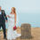 Bride and groom walking along Dorset coastal path near cliff edge, relaxed wedding portraits with sea views