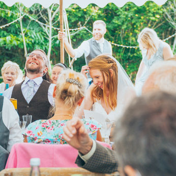 Bride and guests laughing during wedding speeches at marquee reception – hybrid Dorset wedding photographer and videographer.