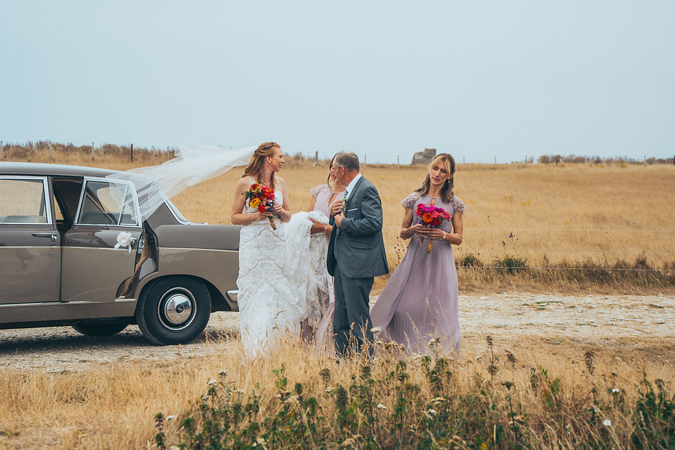 Wedding party arriving at the venue with a vintage car, the couple and their loved ones smiling and chatting before the ceremony.