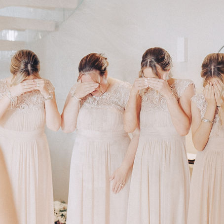 Four bridesmaids cover their eyes in anticipation as the bride prepares for the big reveal.