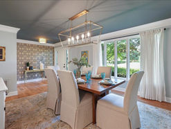 Transitional dinning room with rectangular wooden table and large windows.