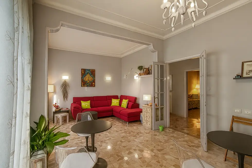 Sala comune luminosa e ristrutturata nel 2024, con divano rosso, tavoli rotondi e sedie per relax, lavoro al computer o lettura