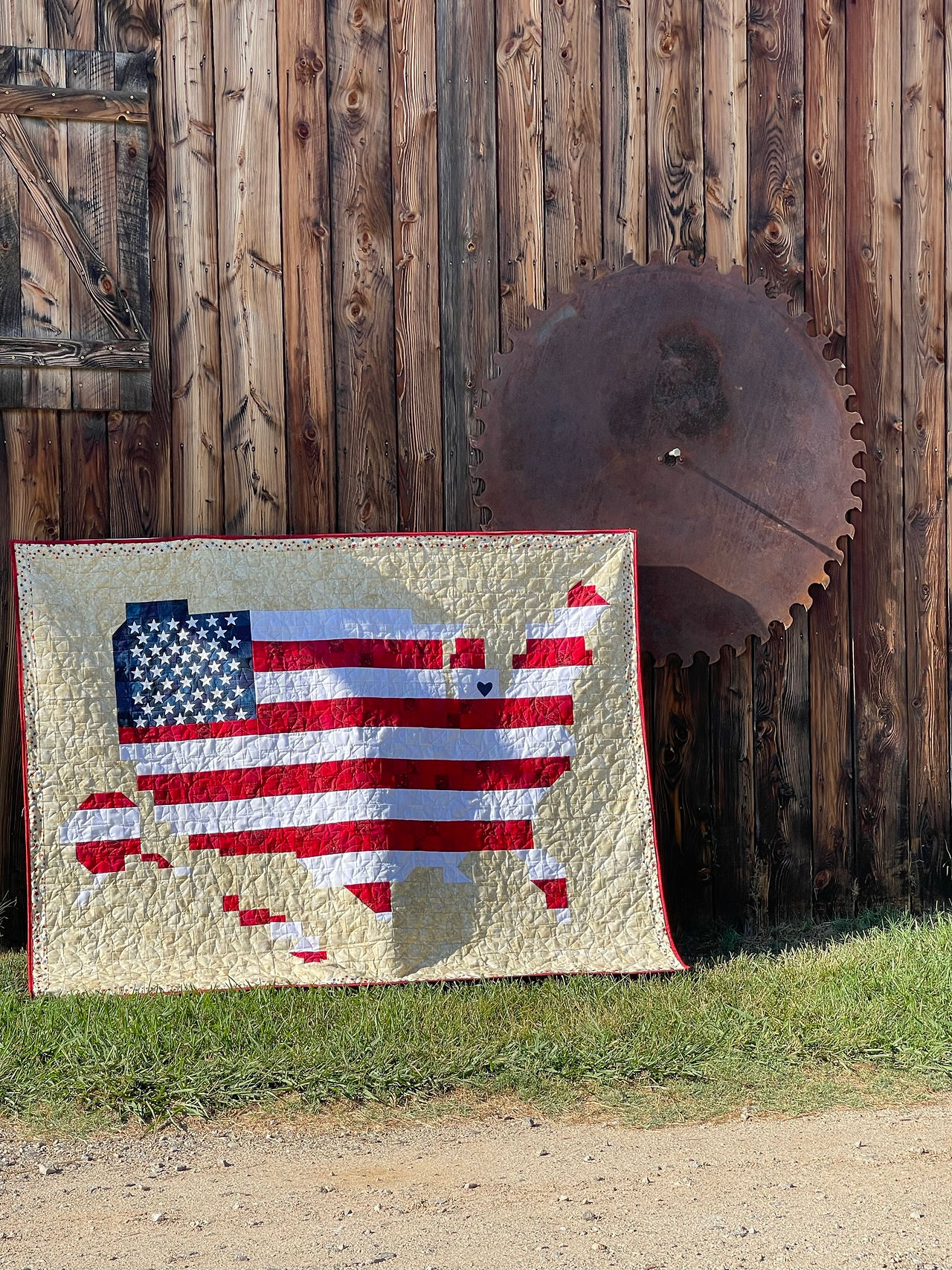 US quilt with barn in background