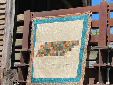 Photo of The Volunteer State quilt, a pixelated design of the state of Tennessee hanging on a bridge.