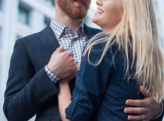 Reconnected Denver Professional Couple embracing and smiling, man has red beard, hair woman blond both wearing dark blue suit