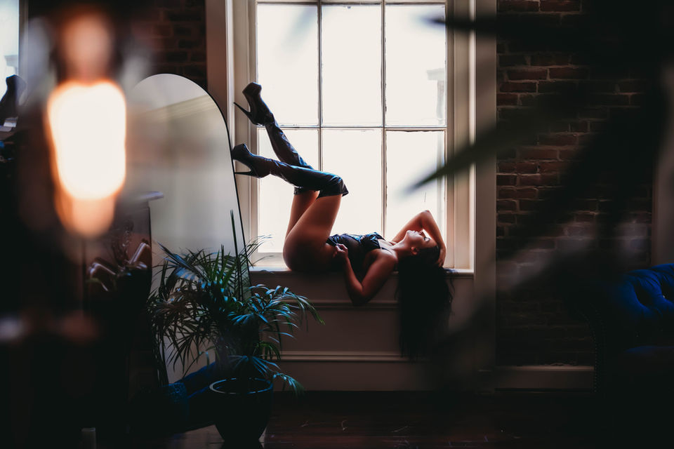 Dramatic window boudoir portrait with natural light at Phoenix Boudoir Galveston