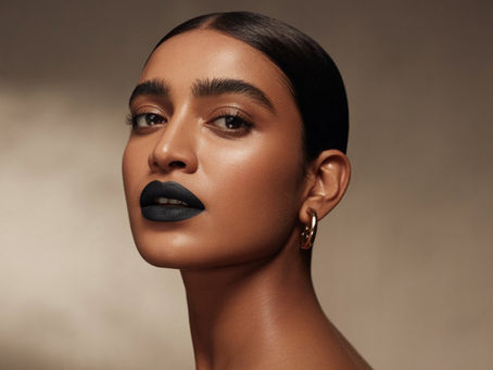 Indian woman wearing matte black lipstick with minimal makeup and glowing skin, representing the bold beauty trend of 2025.