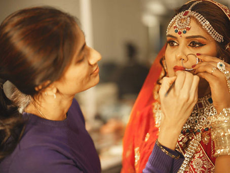 Professional makeup artist applying bridal makeup to an Indian bride during hands-on bridal makeup training at First Foundation Pro, Hyderabad's leading professional makeup academy for bridal makeup courses, hairstyling classes and beauty certification.