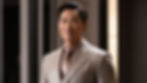 Image of a confident, well-groomed man with a natural makeup look, highlighting even skin tone, groomed brows, and light contouring in a sleek and modern setting.