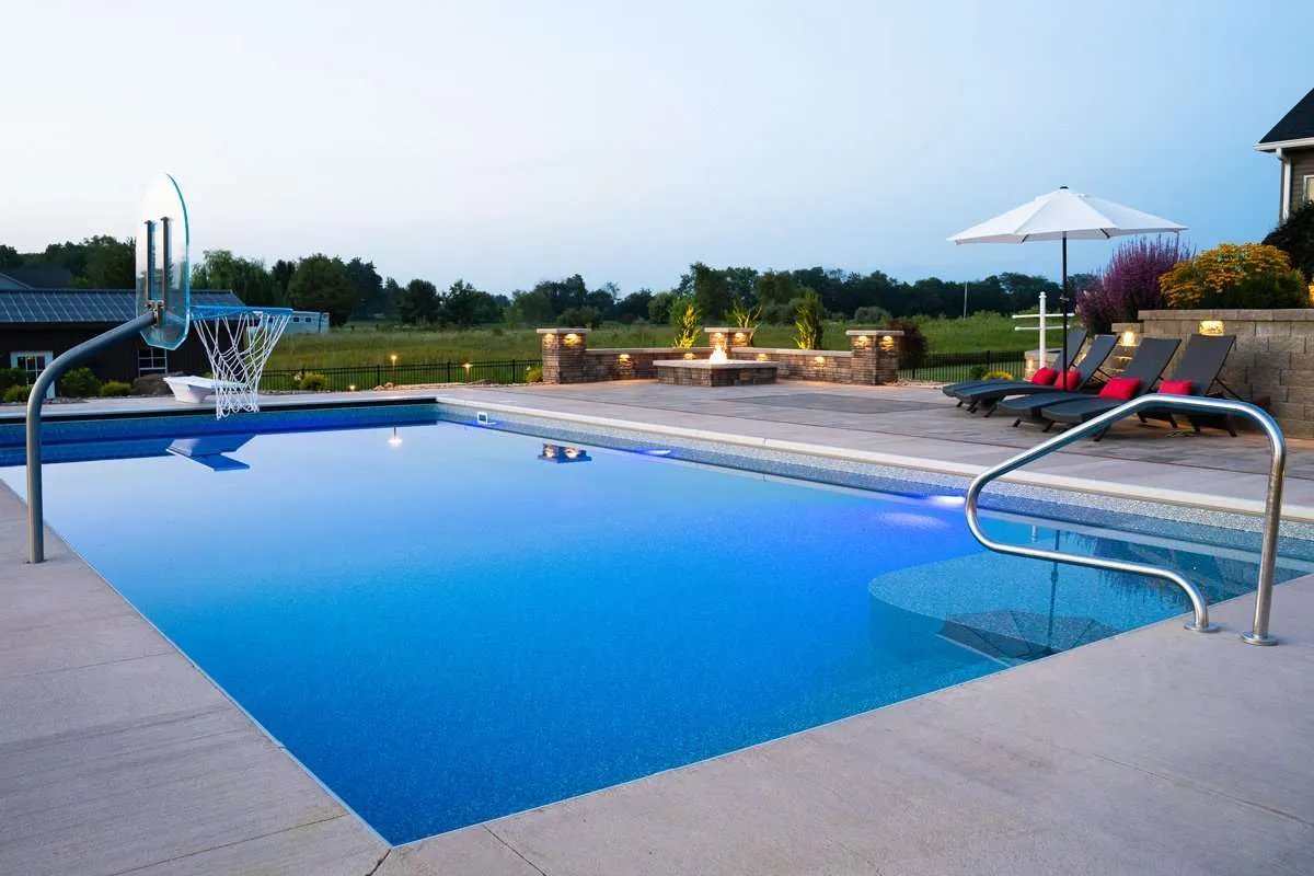A large inground swimming pool with patio built around for a residential home. Space designed by Knob Hill Landscape Company in Springfield, Illinois.