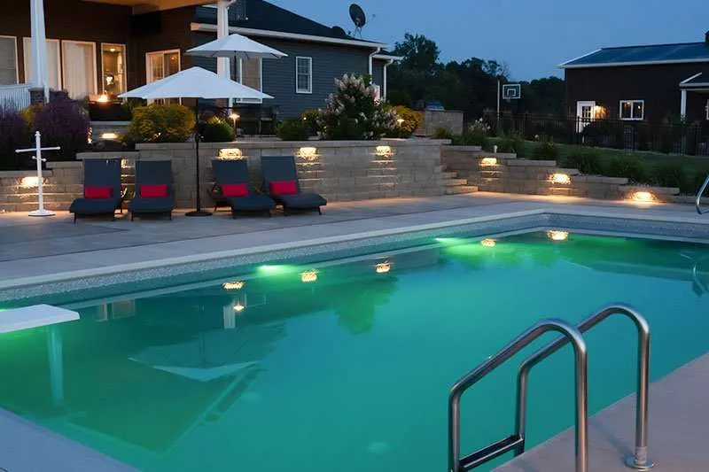 A large inground swimming pool with patio built around for a residential home. Space designed by Knob Hill Landscape Company in Springfield, Illinois.