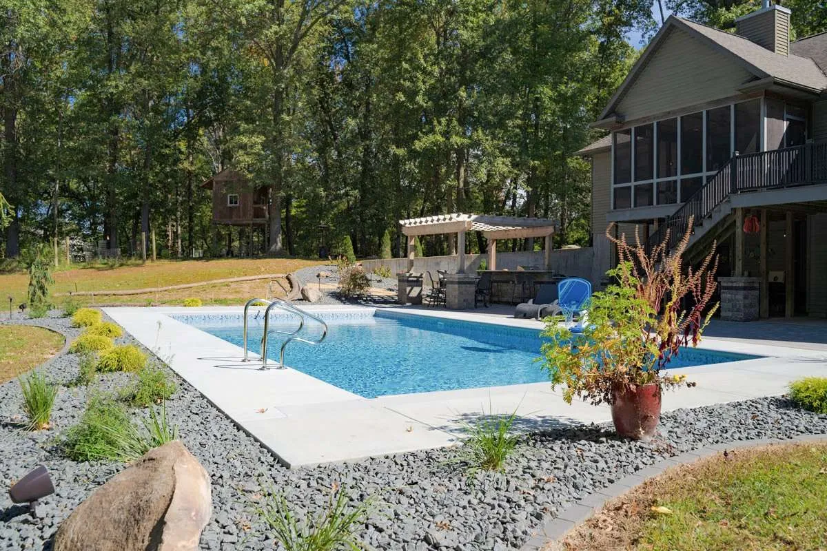 A large modern home with backyard landscaping, a patio, and inground pool designed by Knob Hill Landscaping Company of Springfield, Illinois. 