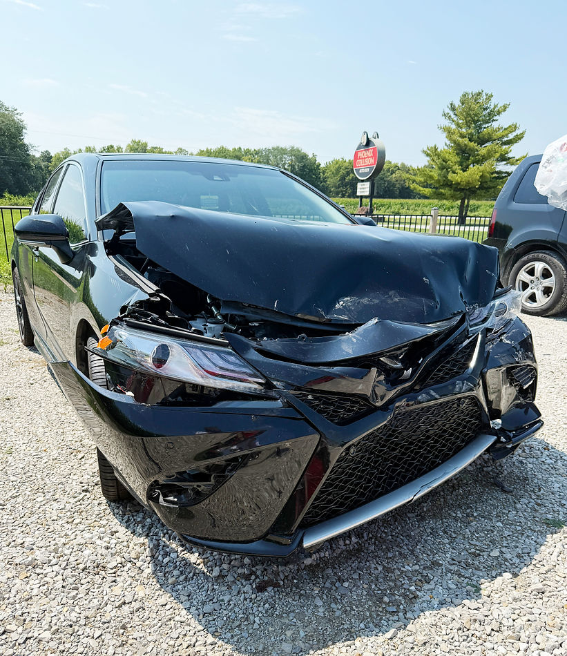 A car with a smashed front hood, bumper, and headlights at Phoenix Collision in Springfield, Illinois after an accident.