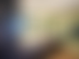 Modern bathroom with dual sinks, glowing mirrors, green walls, dark wood cabinets, and blue floral towels. A digital clock shows 9:08.