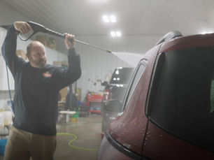 Phoenix Collision employee performing a car detailing service on an SUV in Springfield, IL